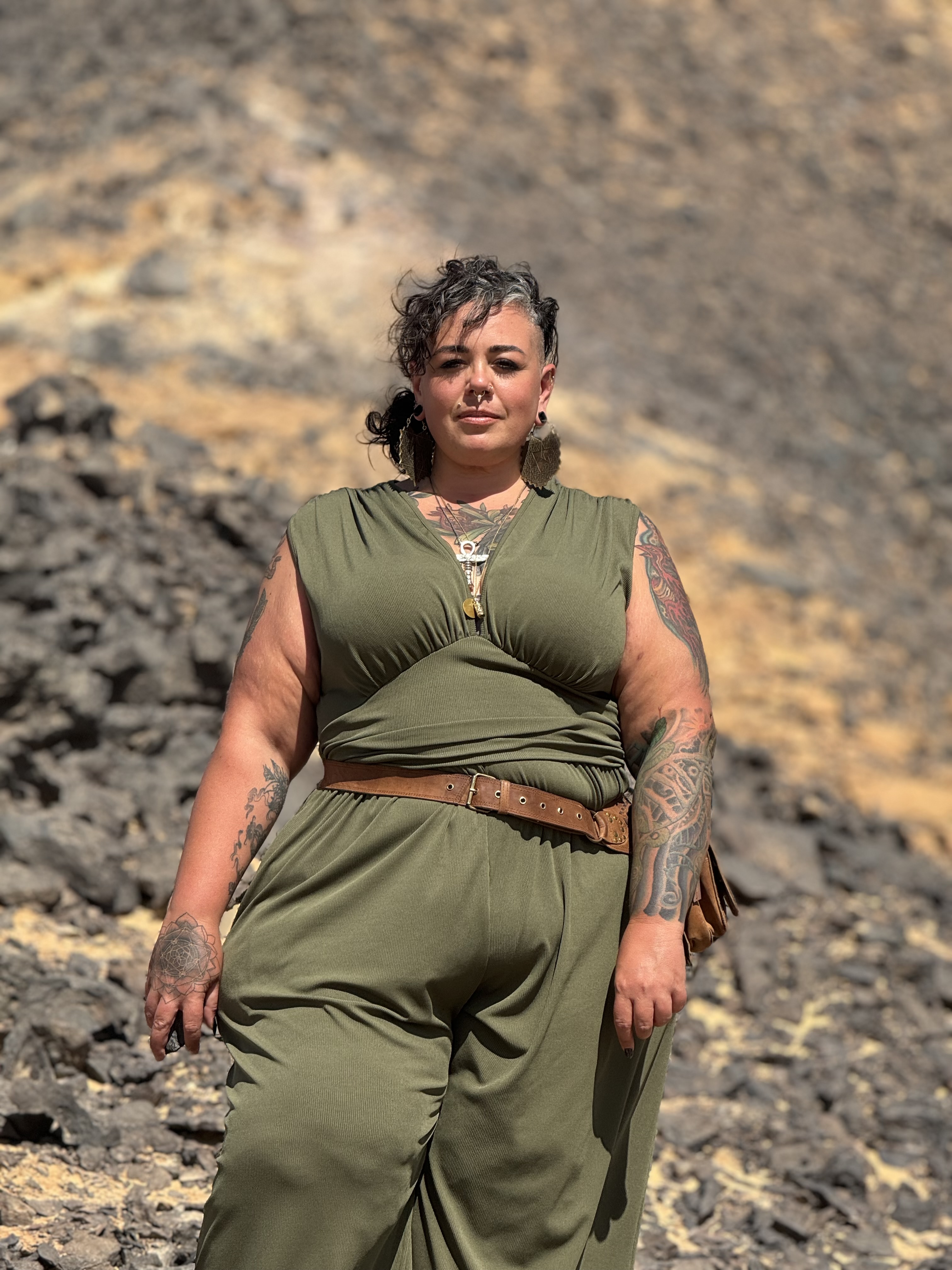 Julieanne Combest — Living Temple founder, standing confidently on volcanic rock